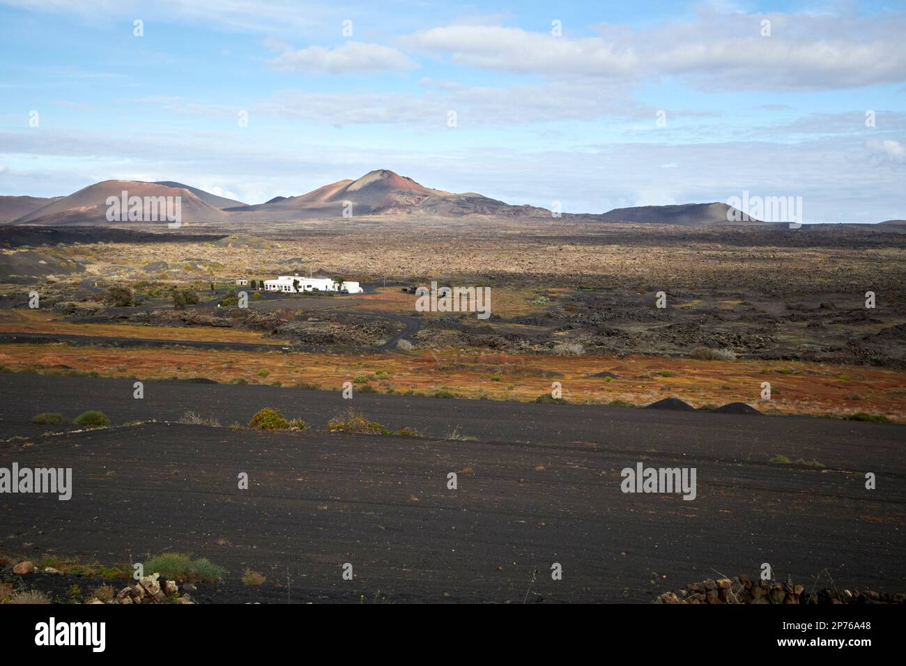 picon covered fields and farmhouse in remote la geria winemaking region landscape with volcanoes in the background Lanzarote, Canary Islands, Spain Stock Photo
