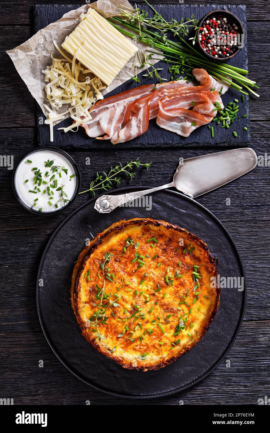 Hash Brown crust bacon and cheddar quiche on black plate with chives