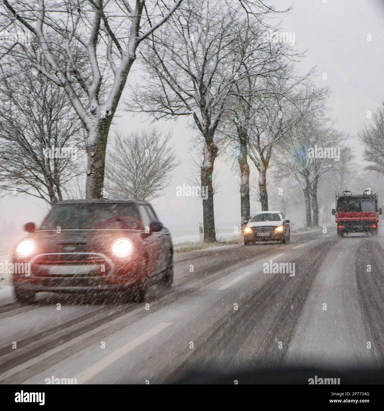 Später Wintereinbruch im Rheinland. Auf der Landstrasse bei Willich schleichen die Autos durch den Schnee. Stock Photo