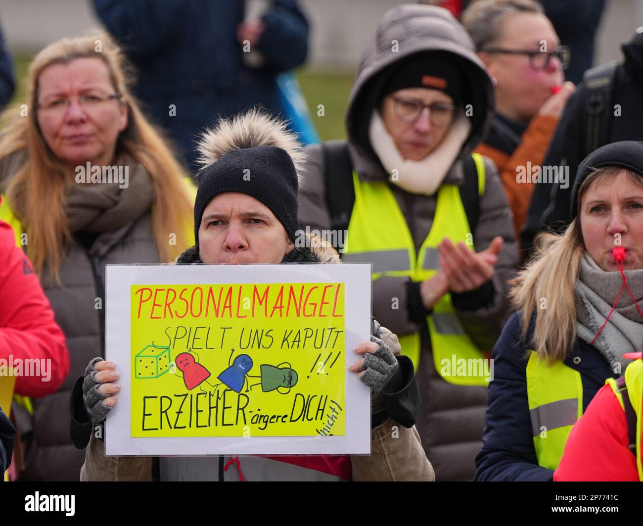 Hennigsdorf, Germany. 08th Mar, 2023. The participant of a demonstration for the International Women's Day on the town hall square holds a poster with the inscription 'Staff shortage plays us kaputt!!! Educators annoy you (not)'. Credit: Soeren Stache/dpa/Alamy Live News Stock Photo
