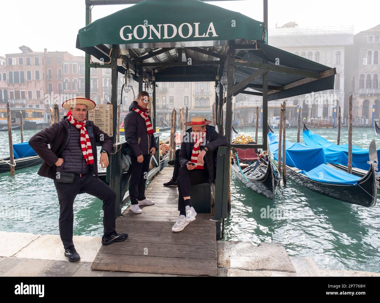 Gondoliers at San Silvestro chat before starting work on the Grand Canal, Venice, Italy. Stock Photo