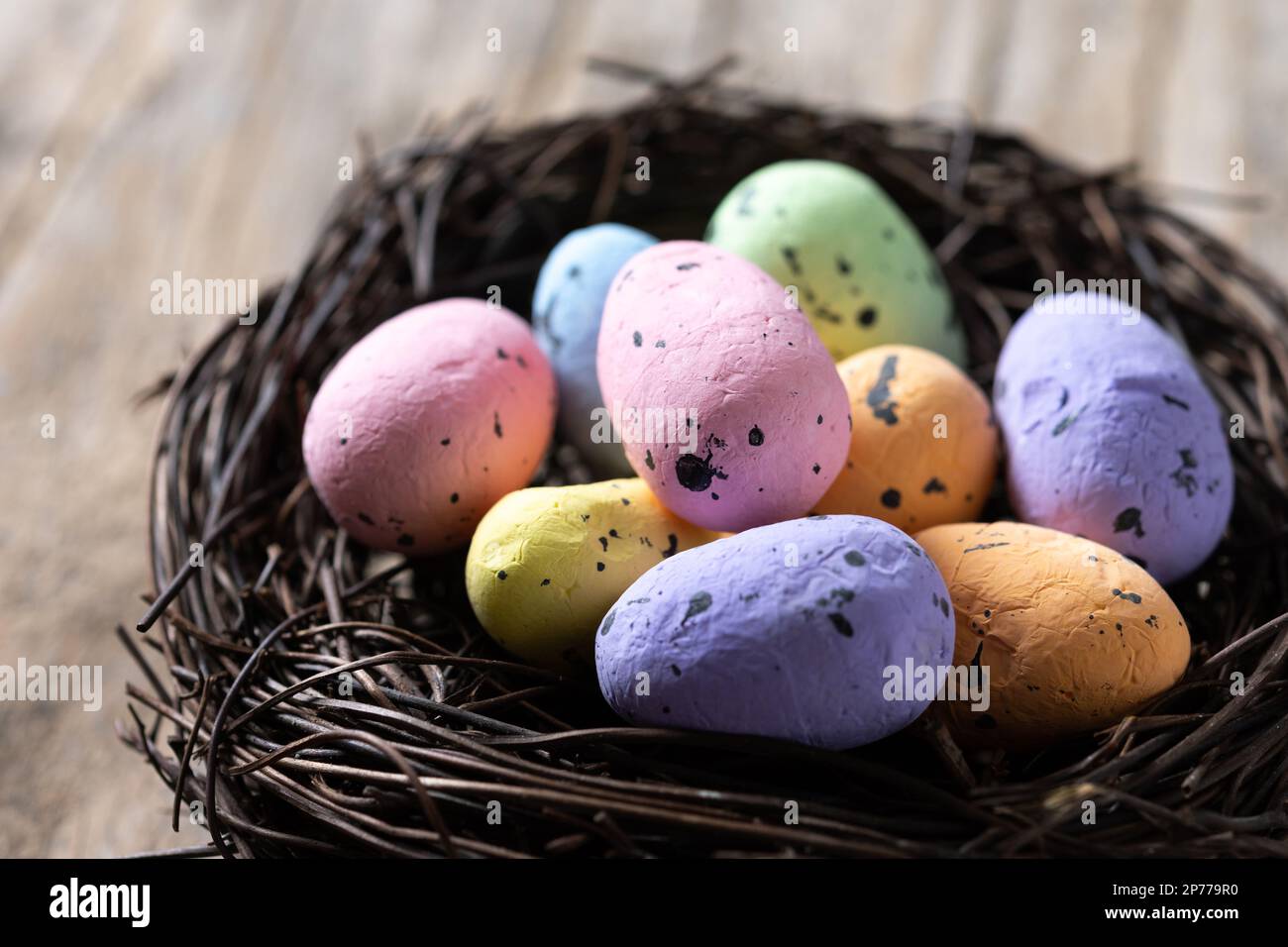 Colorful Easter eggs inside a nest on wooden table Stock Photo