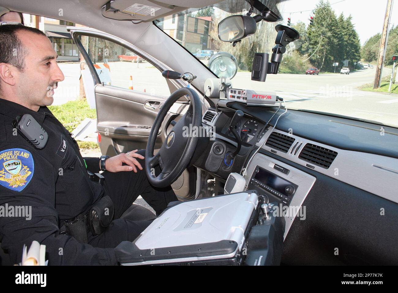 Bainbridge Island Police Officer Victor Cienega mounts his portable camera to the windshield of