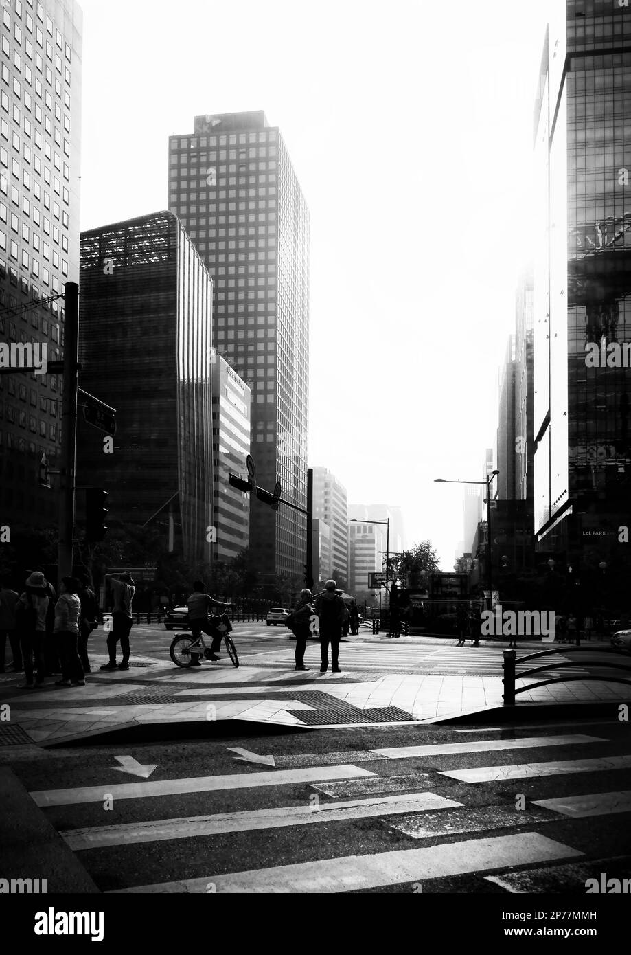 Seoul, South Korea - May 2019:  Seoul road crossing black and white photography with sun illumination and people, car silhouettes Stock Photo