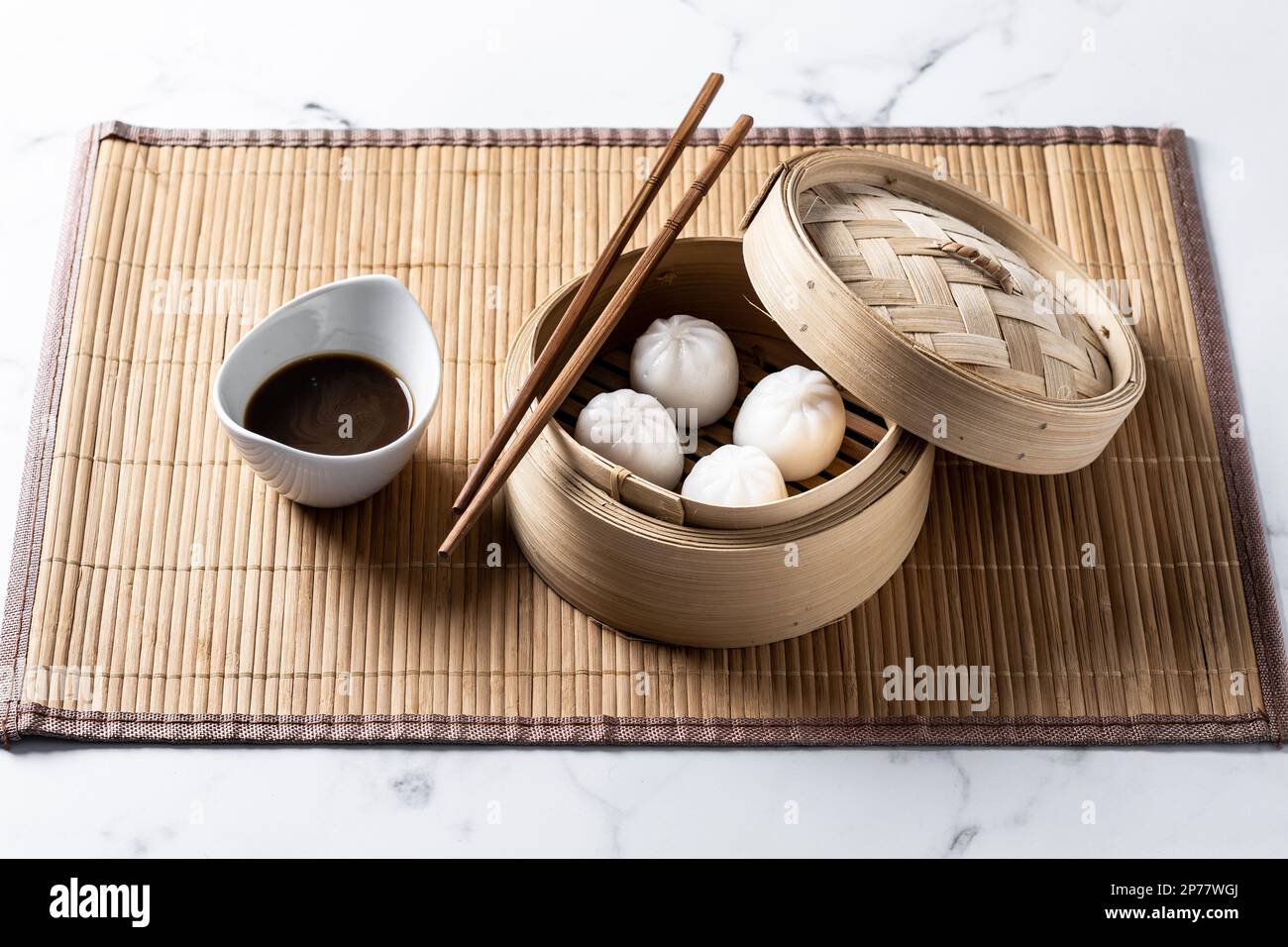 Dumplings in bamboo steamer on marble background Stock Photo