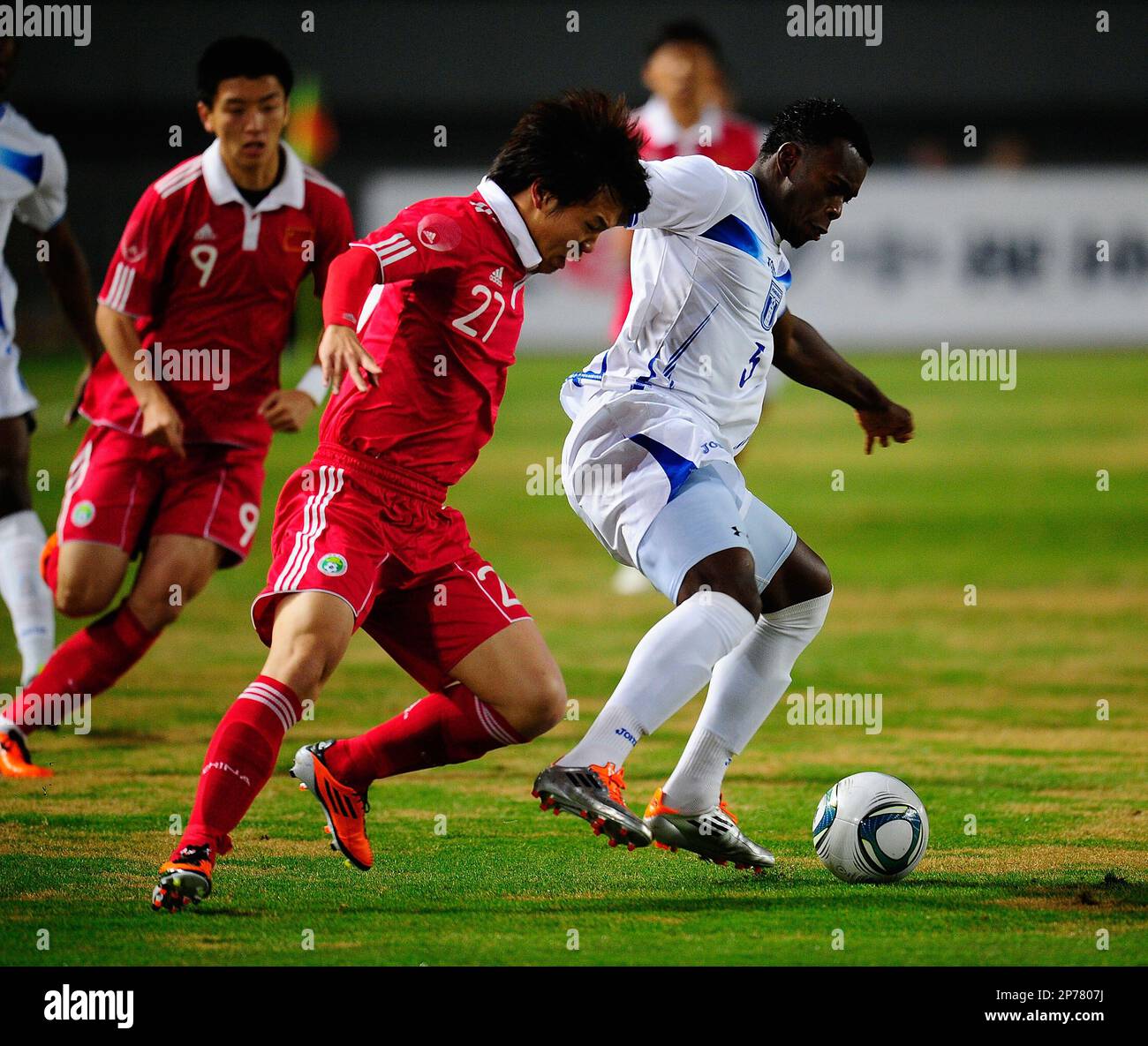 China's Deng Zhuoxiang ( C) vies with Honduras' Erick Norales ( R) during a warmup football match in Wuhan in central China's Hubei province on Tuesday, March 29, 2011. China defeated Honduras 3-0.(Photo By Zhou Guoqiang/Color China Photo/AP Images) Stock Photo