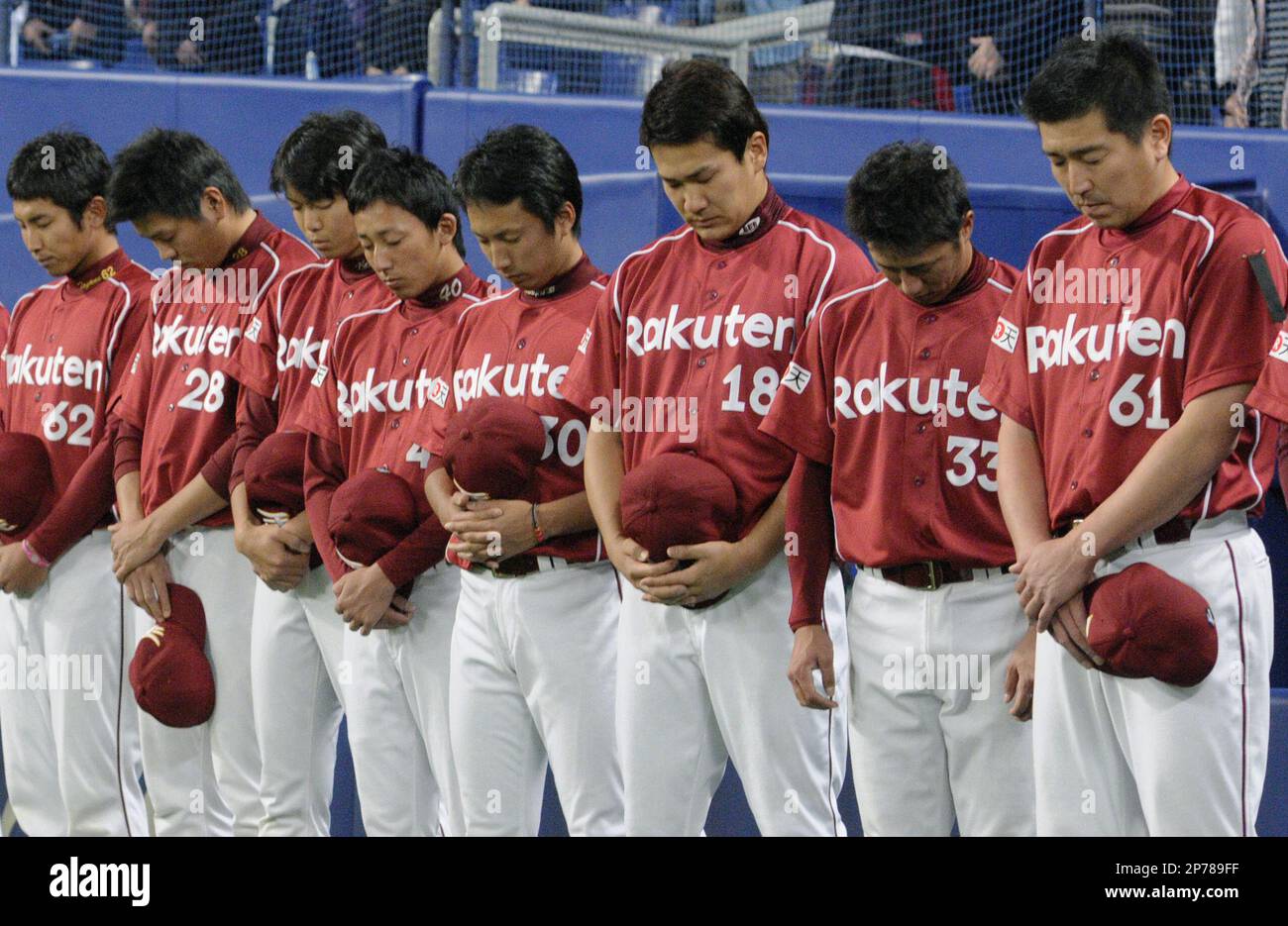 Players of the Tohoku Rakuten Golden Eagles based in Sendai observe a moment of silence for victims of the March 11 earthquake and tsunami before their baseball exhibition game against the Chunichi