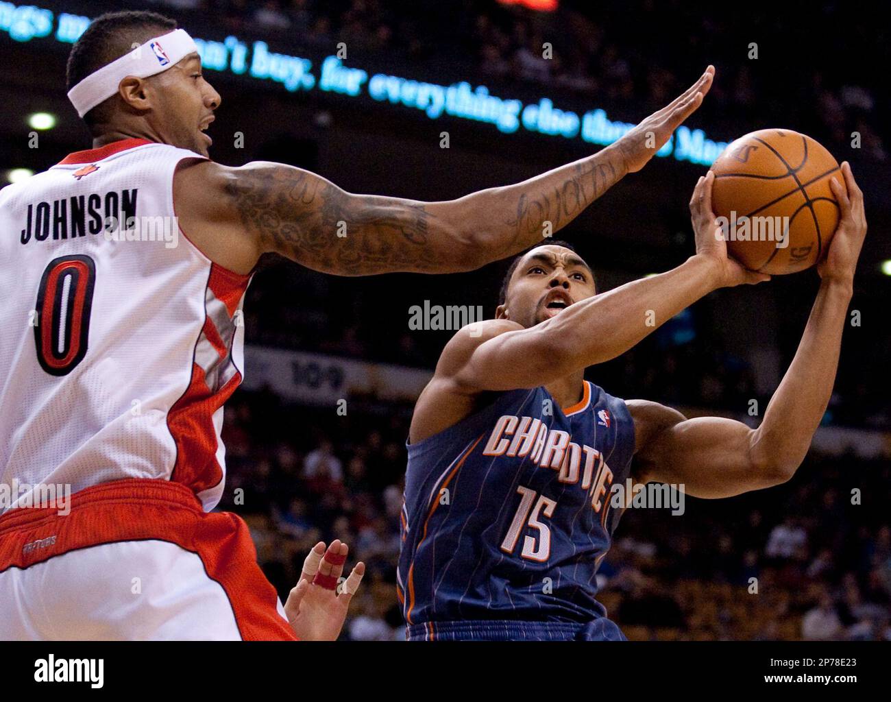 Charlotte Bobcats' Gerald Henderson, right, scores past Toronto Raptors'  James Johnson during first-half NBA basketball game action in Toronto,  Sunday, March 13, 2011. (AP Photo/The Canadian Press, Darren Calabrese  Stock Photo -
