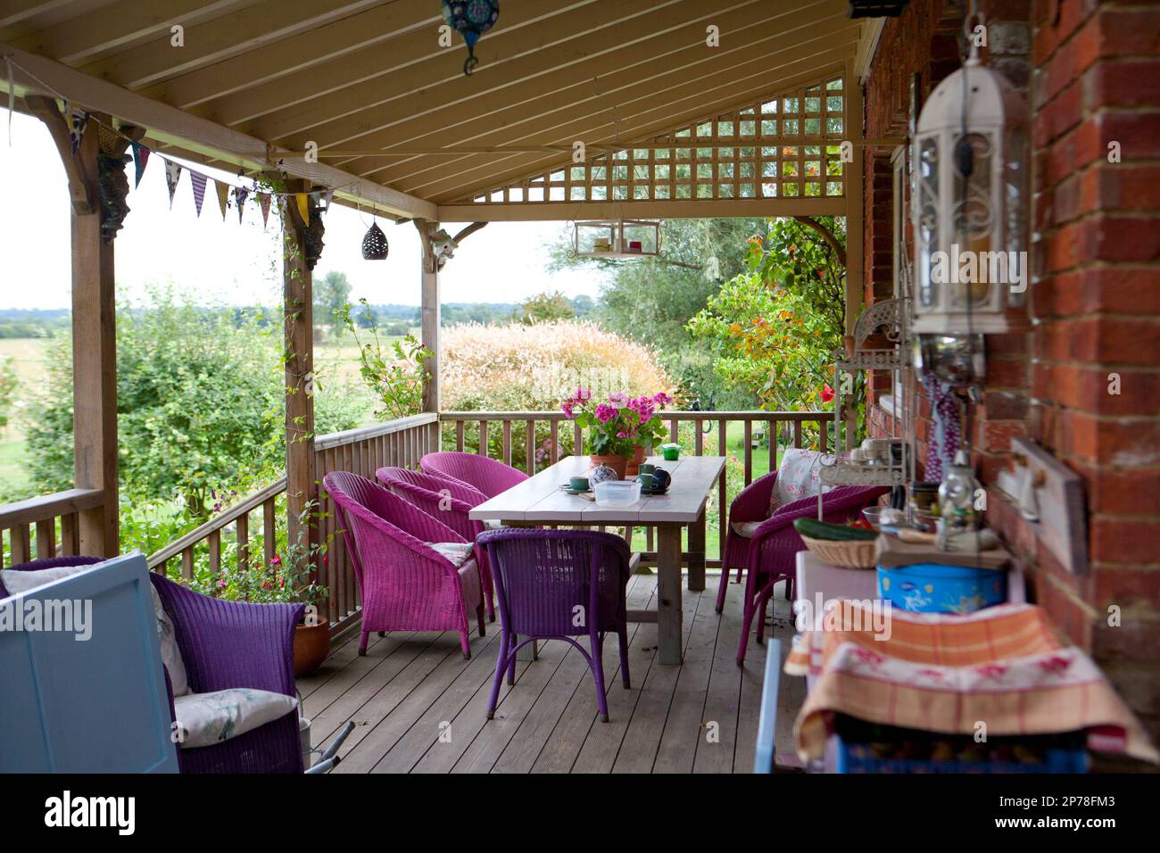 Raised wooden decking area with outdoor seating, surrounded by open countryside Stock Photo