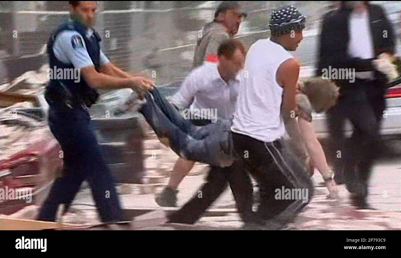 In this image made from video run by New Zealands TVNZ, men carry wounded man after pulling him out from rubble in Christchurch, New Zealand Tuesday, Feb