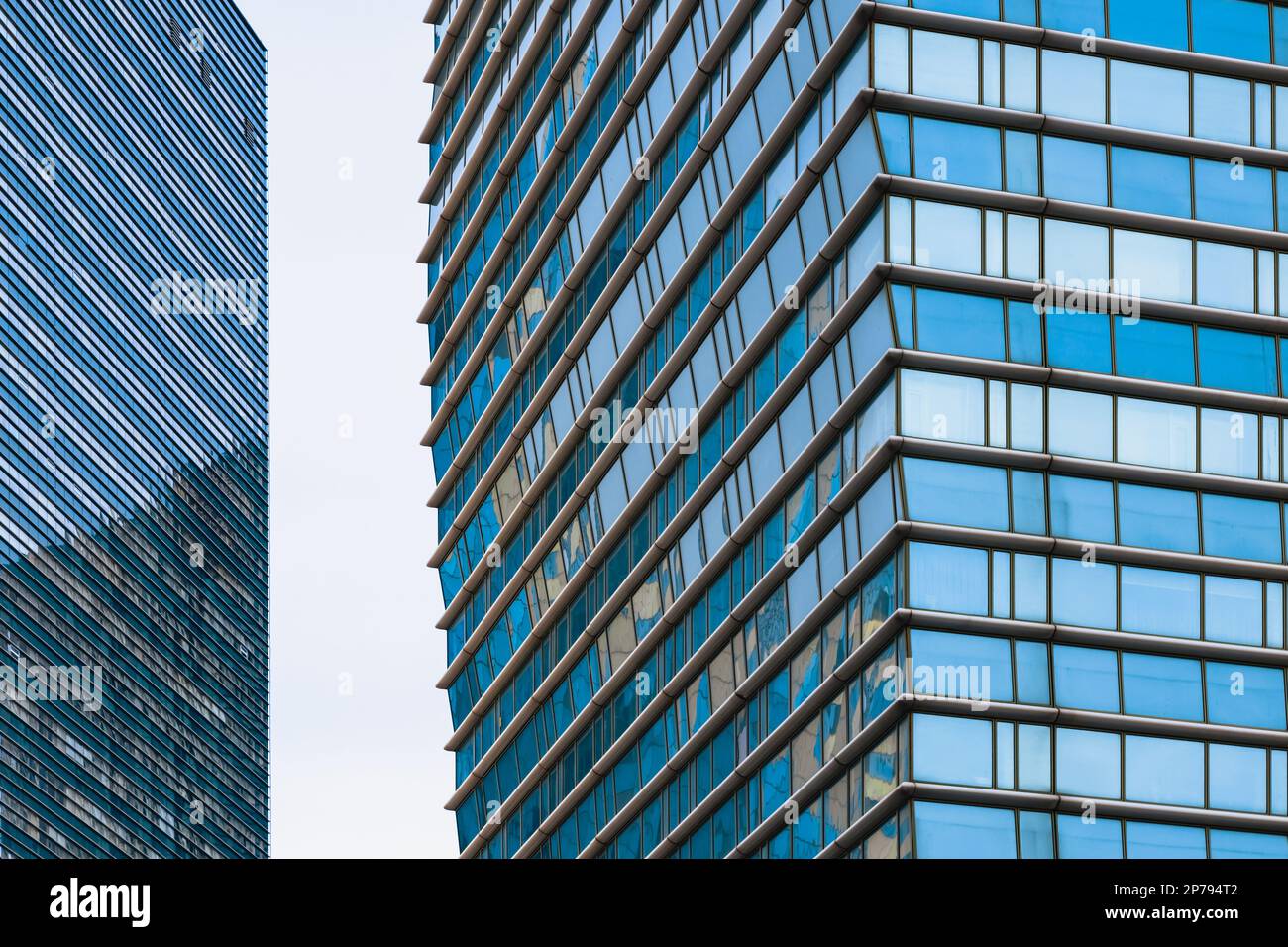 The blue sky is reflected in the windows of a modern office building ...