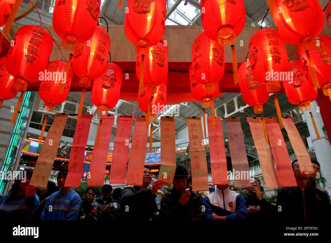 People take part in the riddle guessing during a lantern fair to