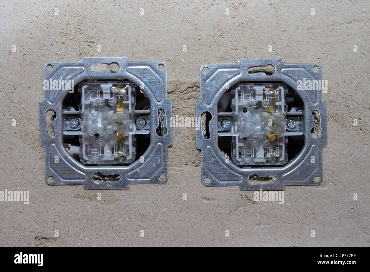 Installation of two electrical contacts on the white wall Stock Photo