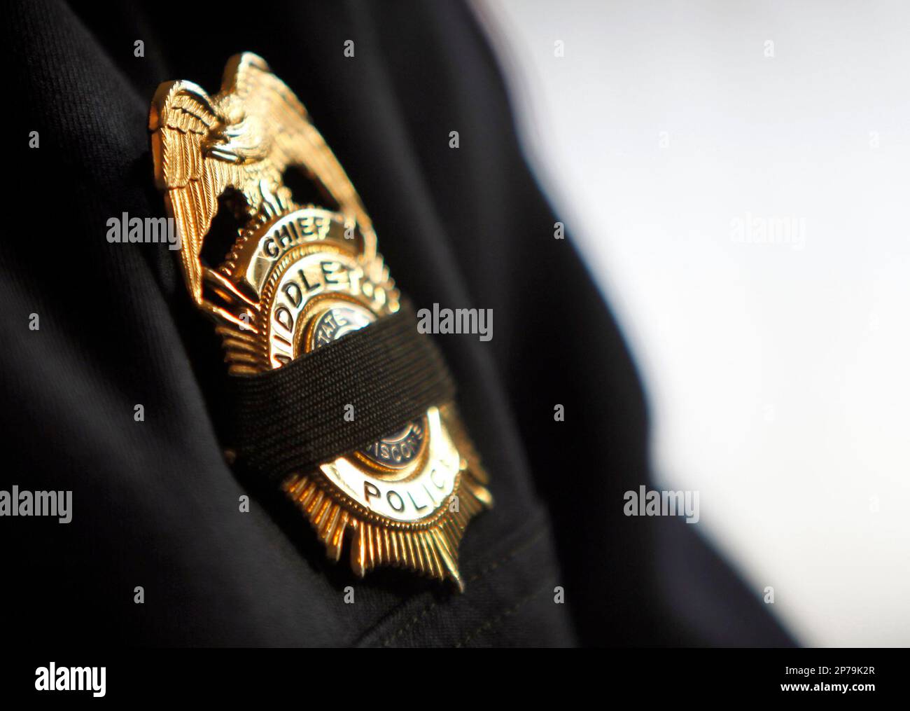 A black mourning band covers the badge of Middleton Police chief Brad Keil  before a funeral Mass for Sgt. Thomas J. Baitinger at St. Bernard Catholic  Parish in Middleton, Wis., Friday afternoon,