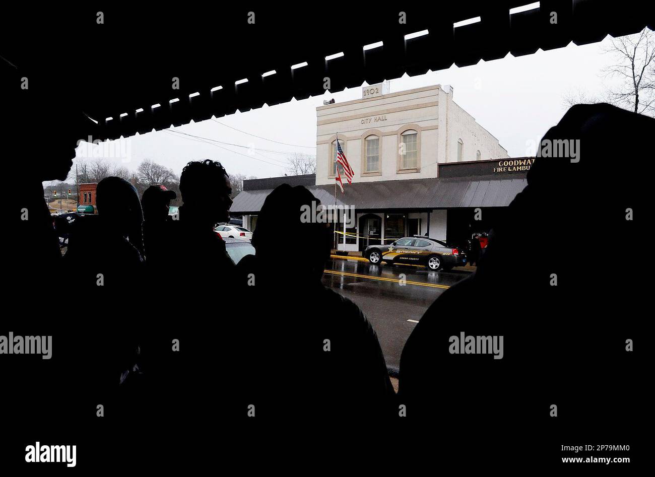 People gather across the street from the Goodwater City Hall in Goodwater, Ala., following a