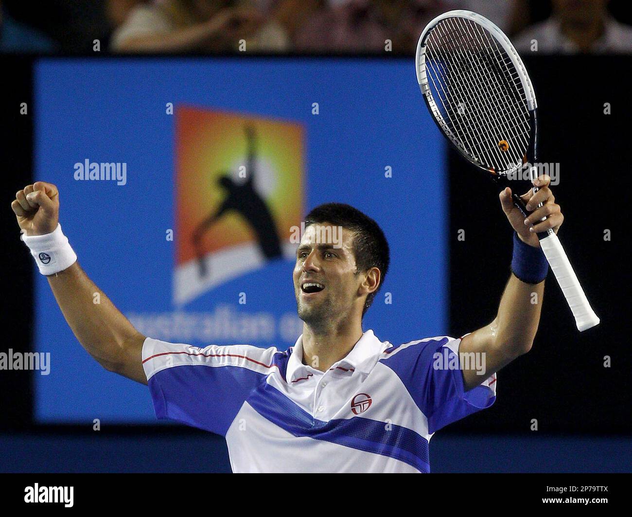 Serbias Novak Djokovic raises his arms in celebration after defeating Britains Andy Murray in the mens singles final at the Australian Open tennis championships in Melbourne, Australia, Sunday, Jan