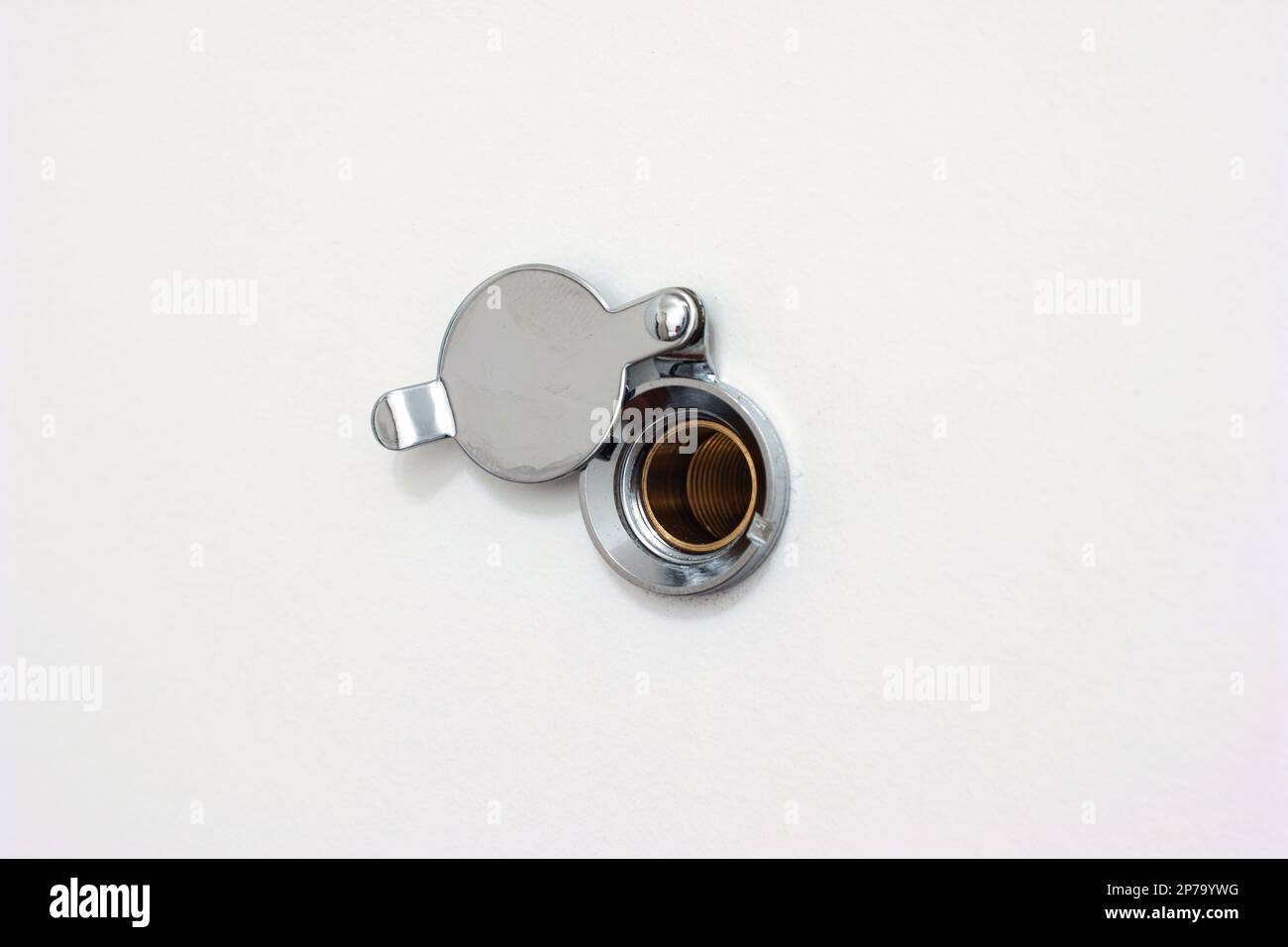 Home door peephole with metal lid cover white wood background macro close up shot. Stock Photo