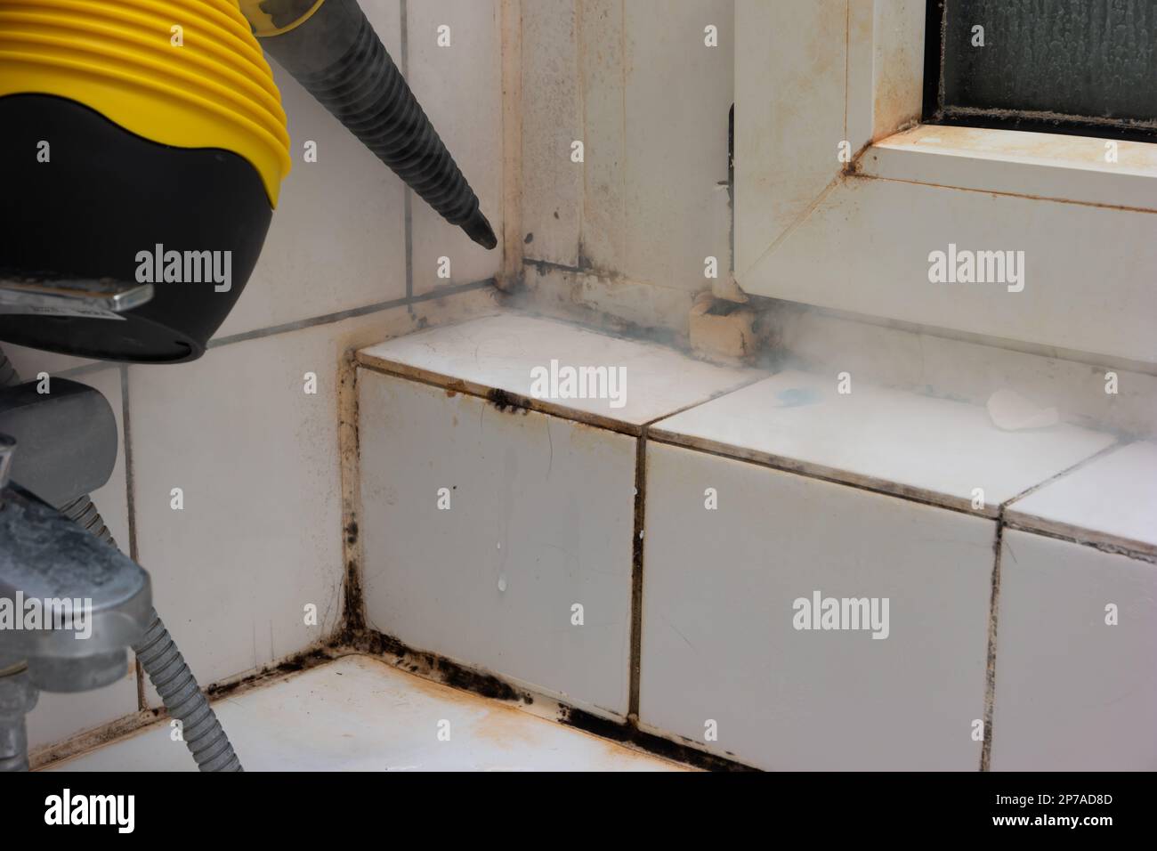 Dirty scaled bathroom tiles cleaning with a steam pressure cleaner