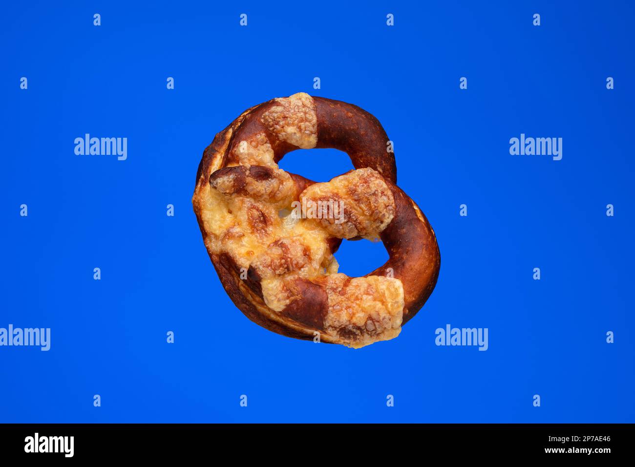 Freshly home backed Pretzel. Close up studio shot, isolated on blue. Stock Photo