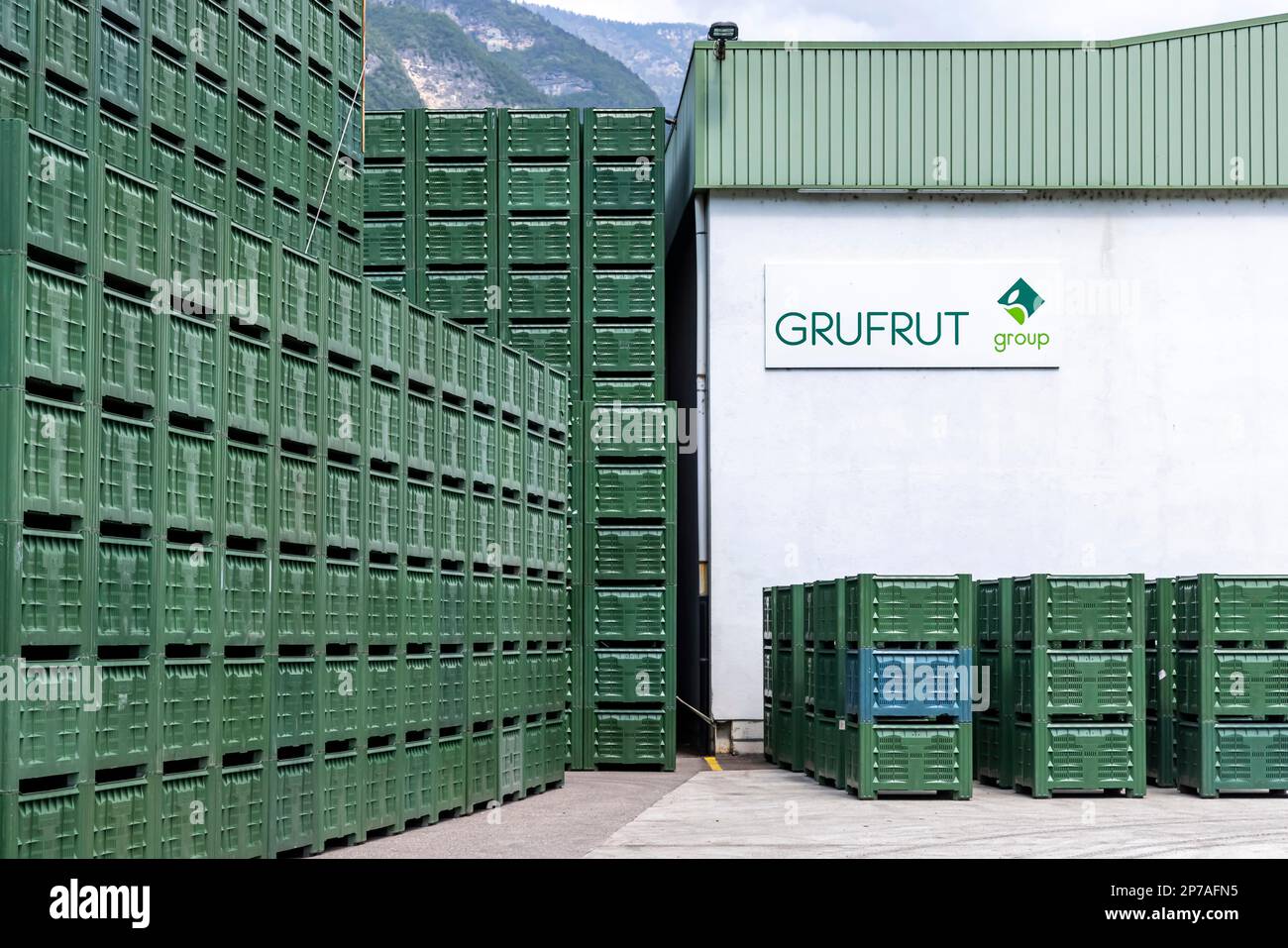Vegetable crates and fruit crates in front of a green mountain. GRUFUT fruit cooperative in Salurn. The approximately 600 members cultivate 1, 300 Stock Photo