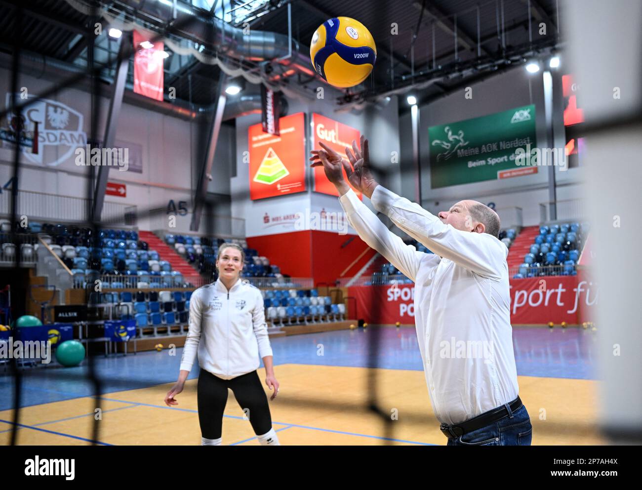 Potsdam, Germany. 08th Mar, 2023. German Chancellor Olaf Scholz (SPD), plays a ball on the court next to volleyball player Pia Leweling during a visit to the training of the SC Potsdam women's volleyball team. Credit: Britta Pedersen/dpa/Alamy Live News Stock Photo