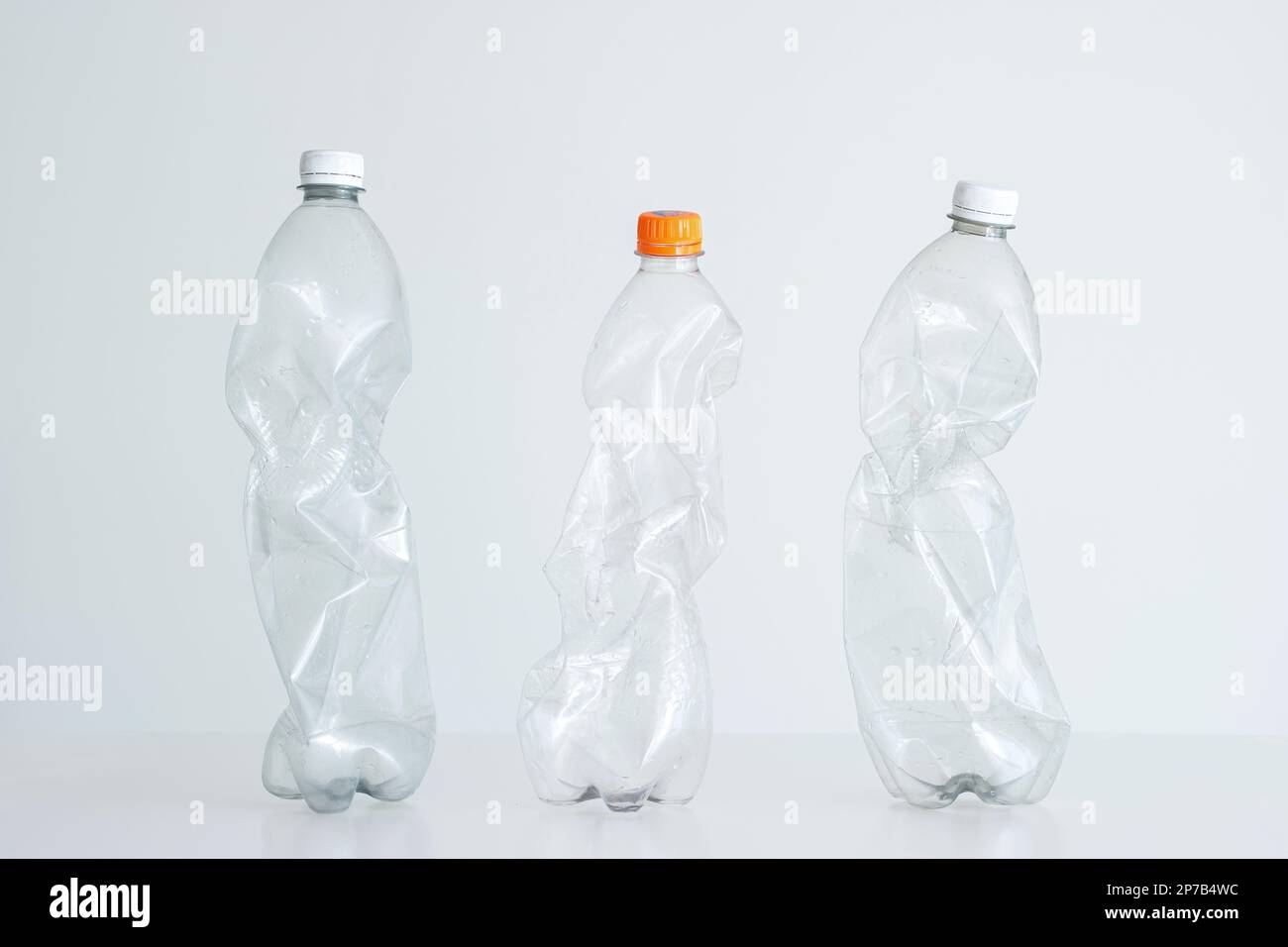 3 large clear squeezed plastic water bottles with close caps. Studio shot, isolated on white, no people. Stock Photo