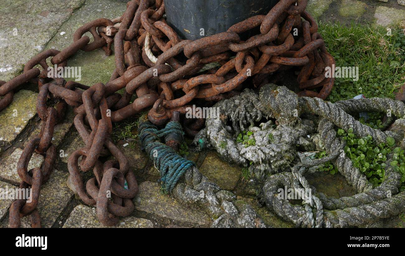 Rusting chain and old rope at harbour edge. Ilfracombe. Devon. England. UK Stock Photo