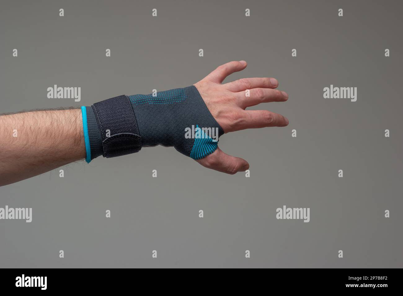Velcro wrist stabilizer cast worn by Caucasian male hand. A blue split