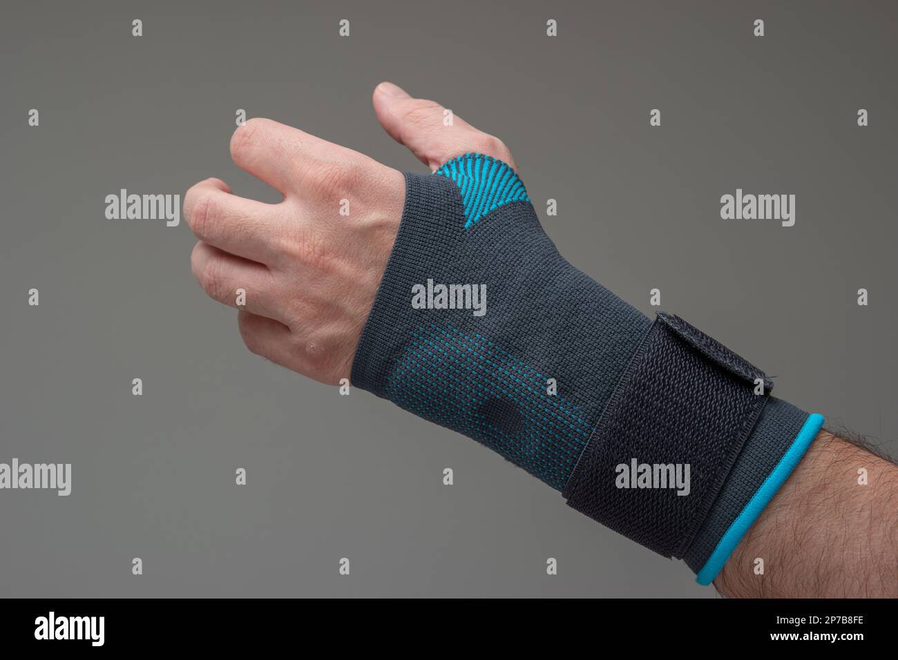 Velcro wrist stabilizer cast worn by Caucasian male hand. A blue split