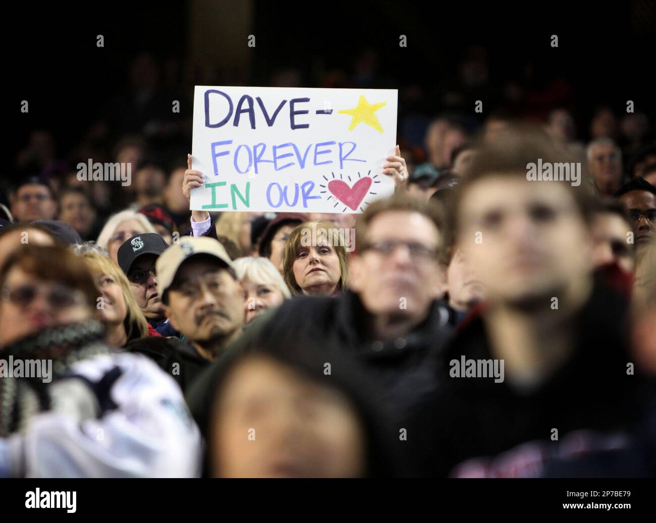 A fan holds up a sign during a celebration of life ceremony for