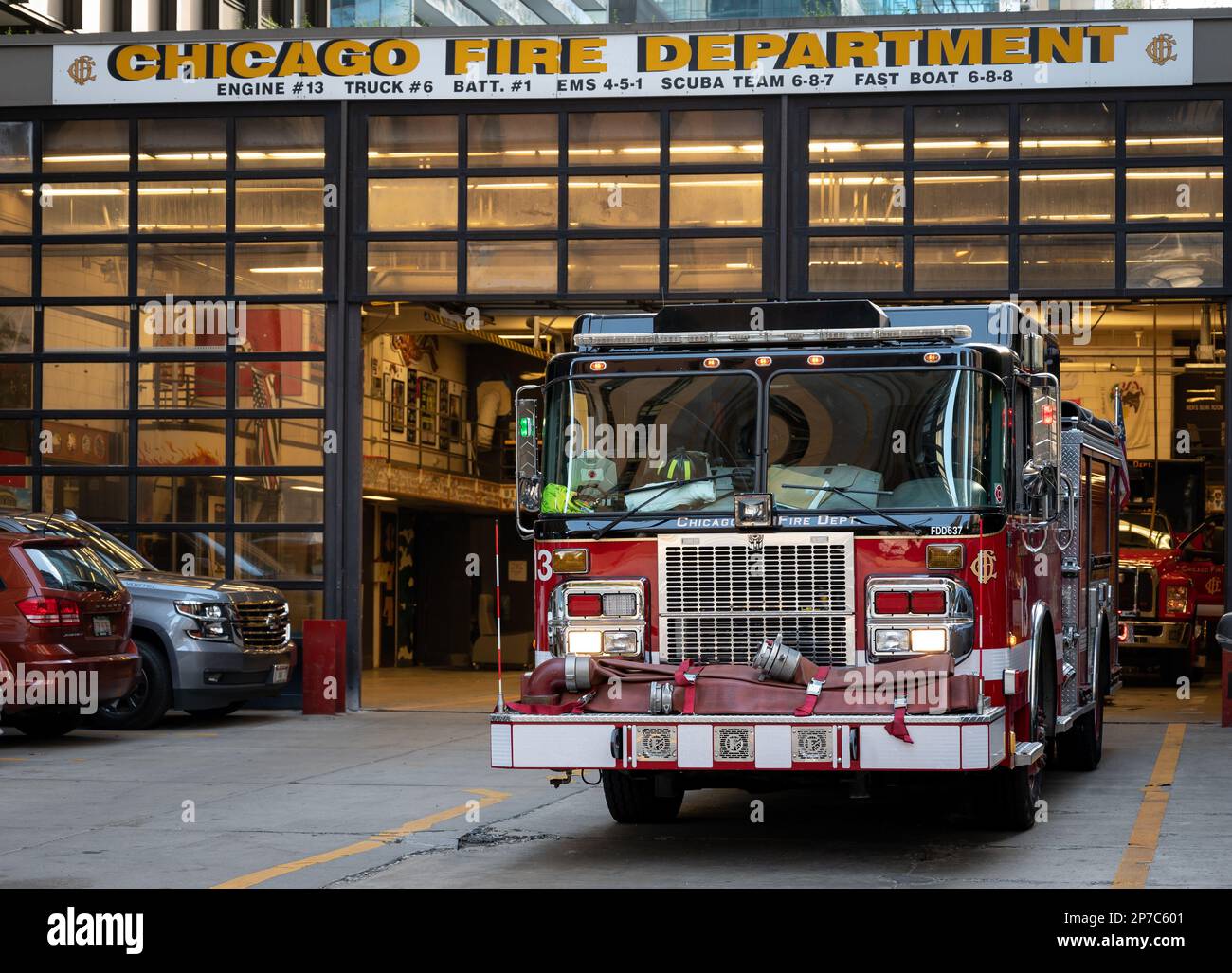 An illuminated red fire truck parked in front of the Chicago Fire ...
