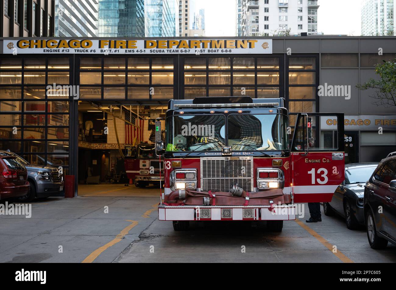 An illuminated red fire truck parked in front of the Chicago Fire