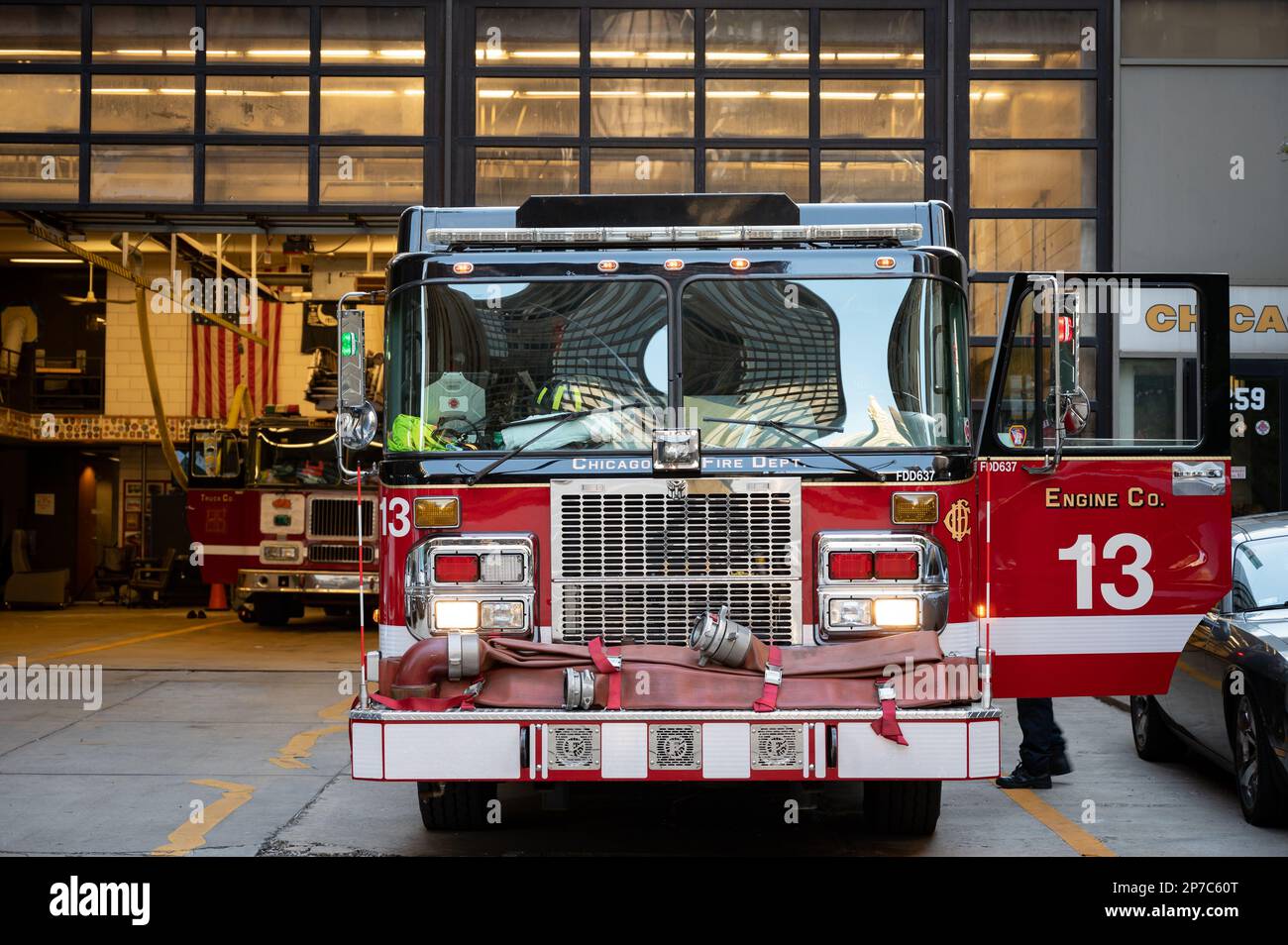 An illuminated red fire truck parked in front of the Chicago Fire ...