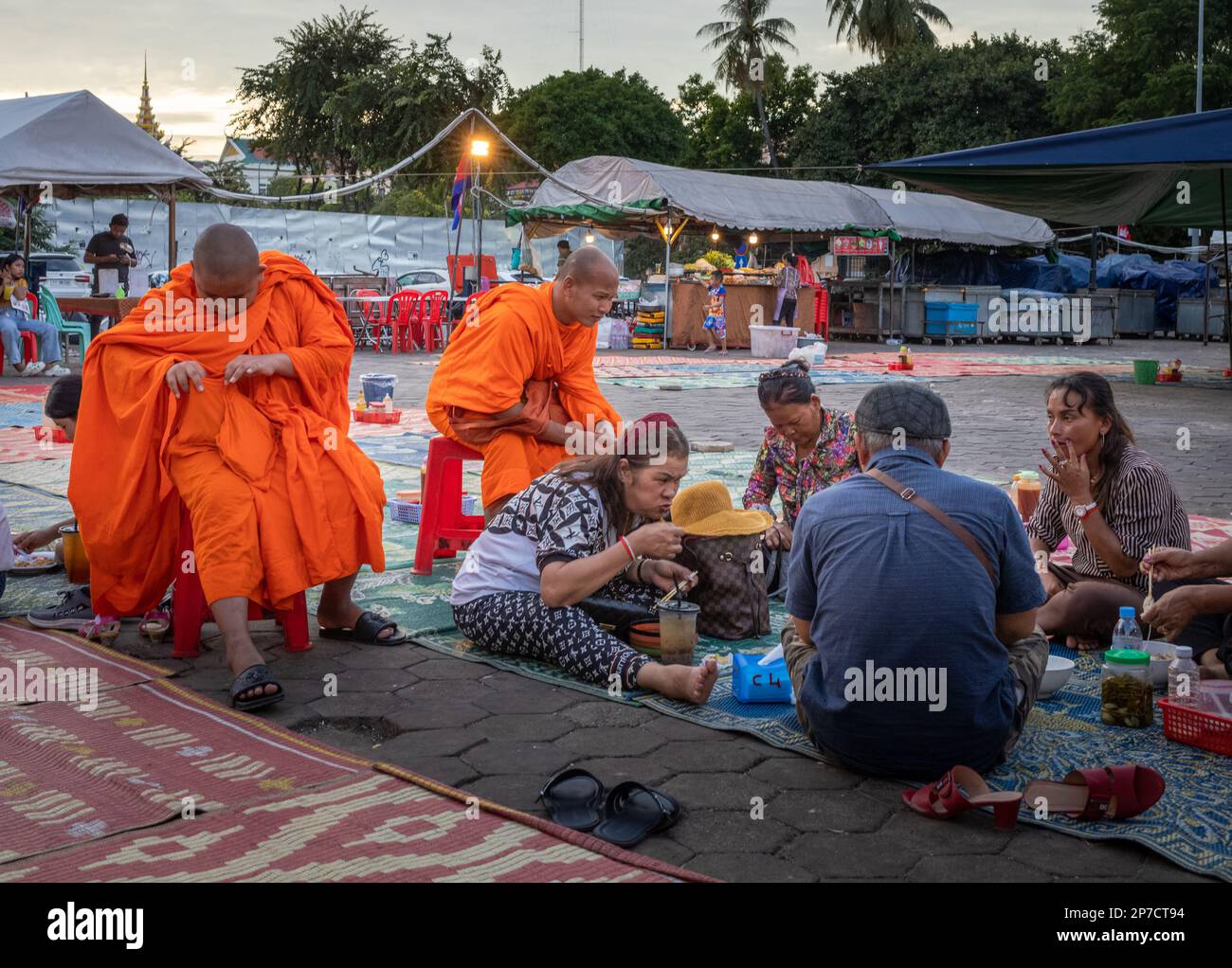 A group of Cambodian people sit on the floor to eat at the night market in Phnom Penh, Cambodia