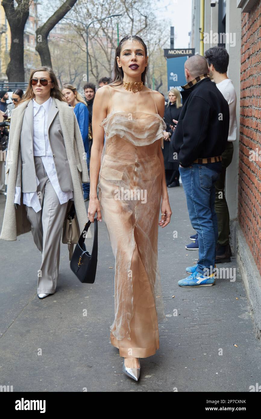MILAN, ITALY - FEBRUARY 22, 2023: Woman with pale pink long dress and silver shoes before Fendi fashion show, Milan Fashion Week street style Stock Photo