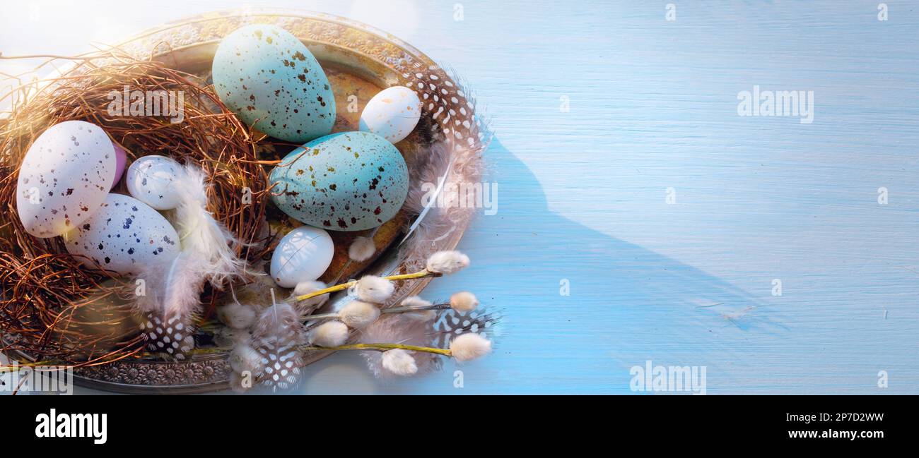 Easter holiday decoration on blue wooden background; sunny Easter morning Stock Photo
