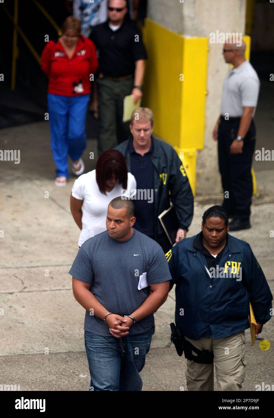 FBI agents escort Puerto Rico police officers after they were arrested in  San Juan, Puerto Rico, Wednesday Oct. 6, 2010. U.S. Federal authorities  arrested about 130 people, including nearly 90 law enforcement