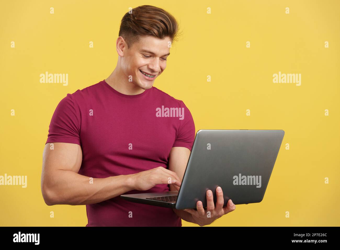 Strong and happy man using a laptop and smiling Stock Photo