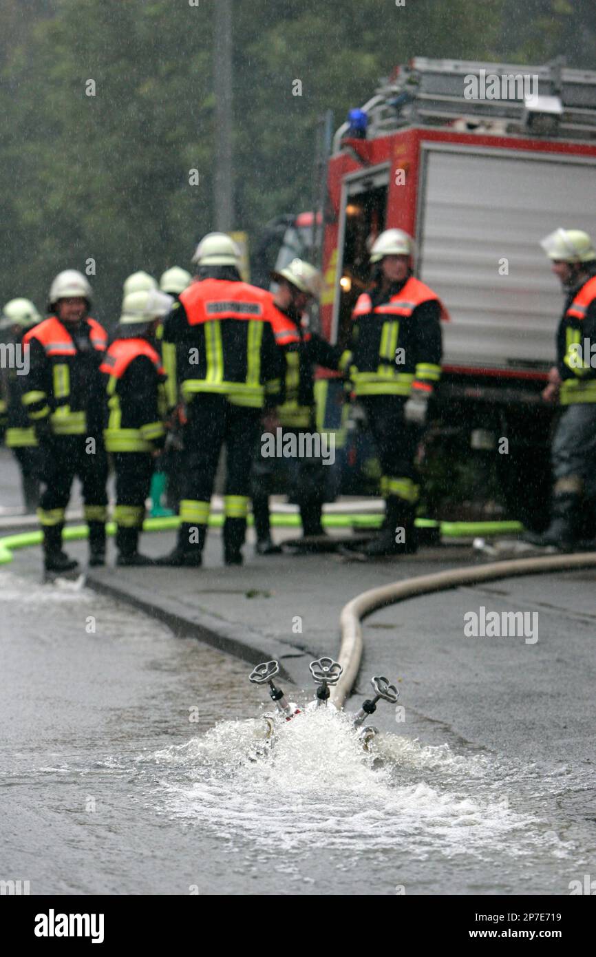 Feuerwehrmaenner pumpen am Freitag, 27. August 2010, in Langenhorst im  Kreis Steinfurt Wasser aus einem ueberfluteten Garten. Nach schweren  Regenfaellen in der Nacht herrscht im Muensterland und im suedlichen  Niedersachsen Ausnahmezustand. (apn