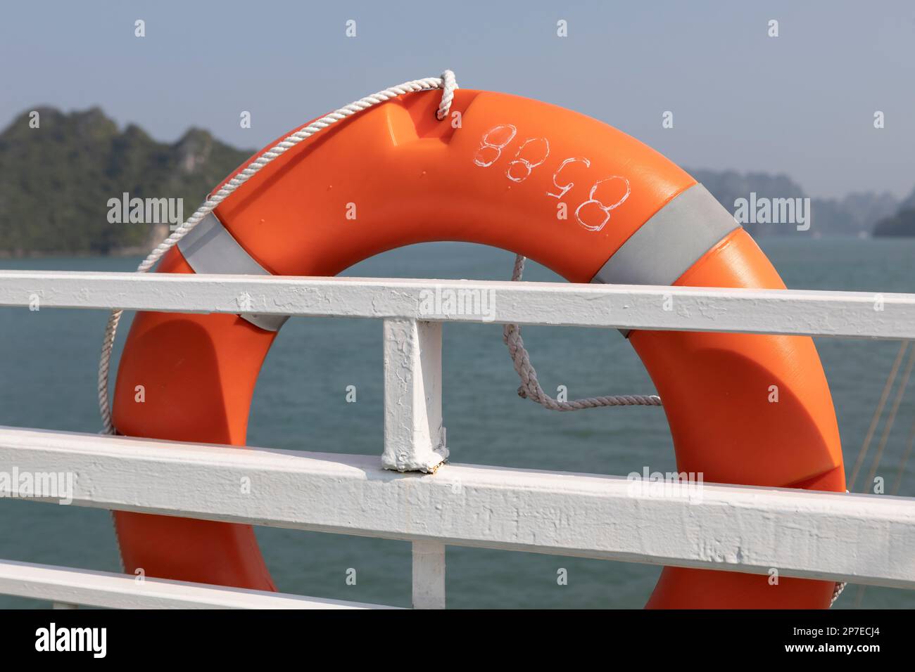 An orange lifebuoy on a cruise ship in Ha Long Bay, Vietnam Stock Photo