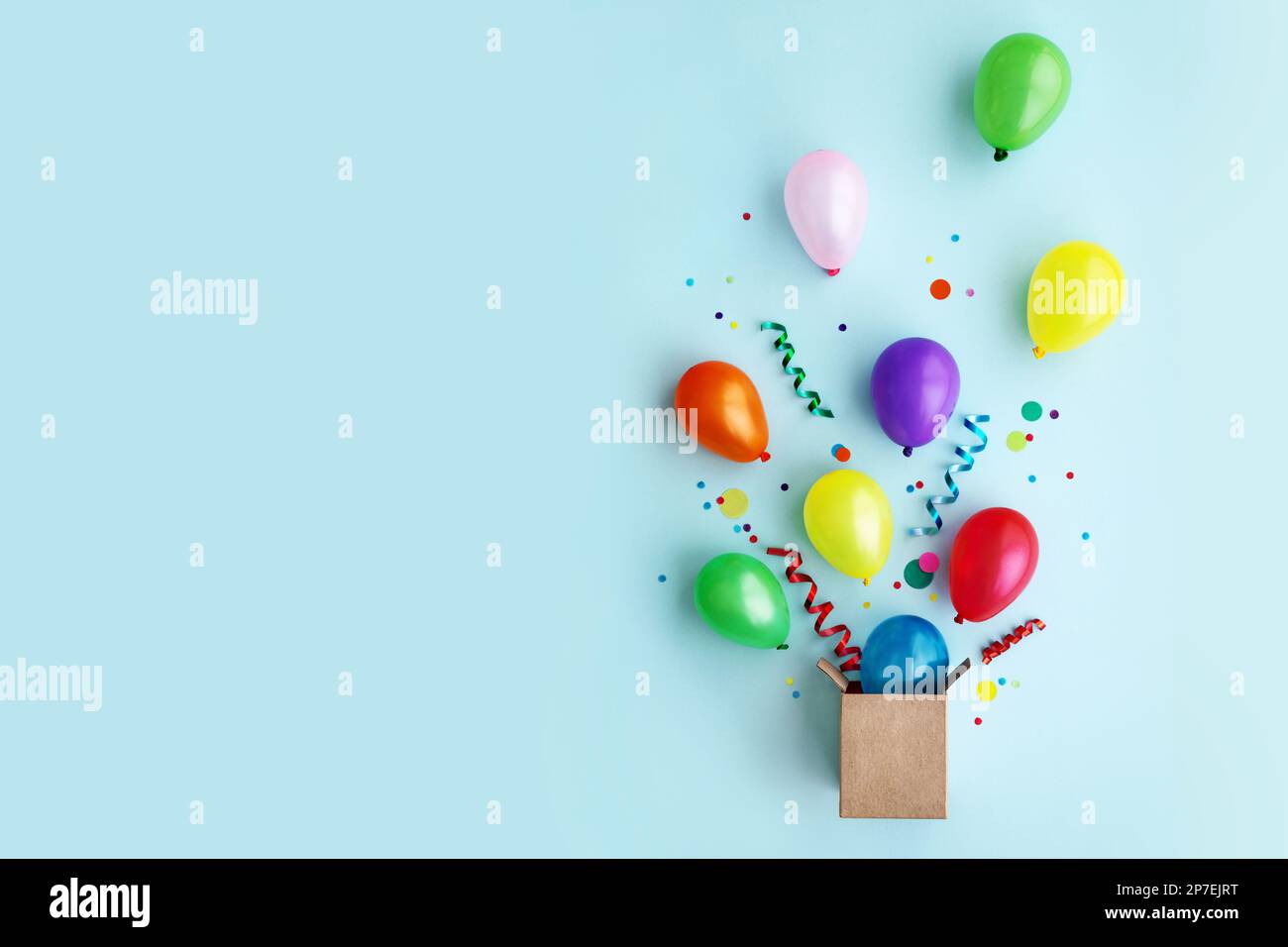 Birthday party flat lay with colorful balloons and confetti escaping from a gift box Stock Photo