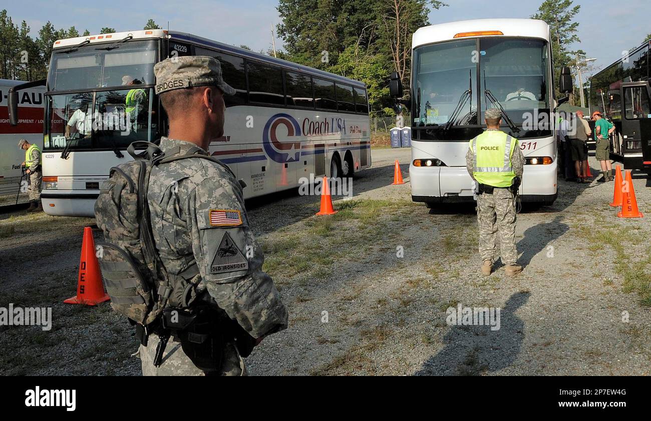 Military personnel inspect the vehicles entering Ft. A.P. Hill for the