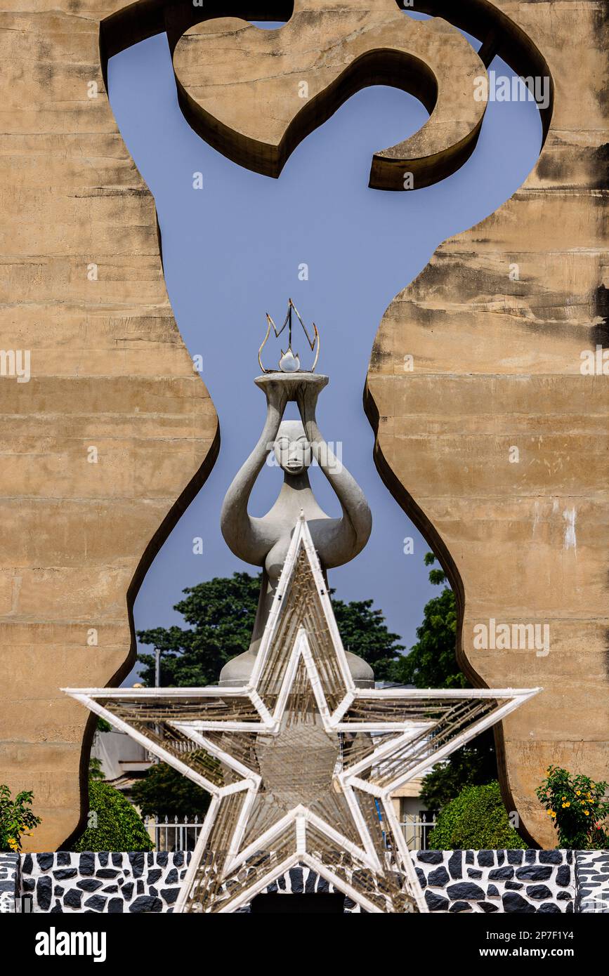 close up view from in front of independence monument in lome togo of human silhouette in stone monument with five point star front and statue behind Stock Photo