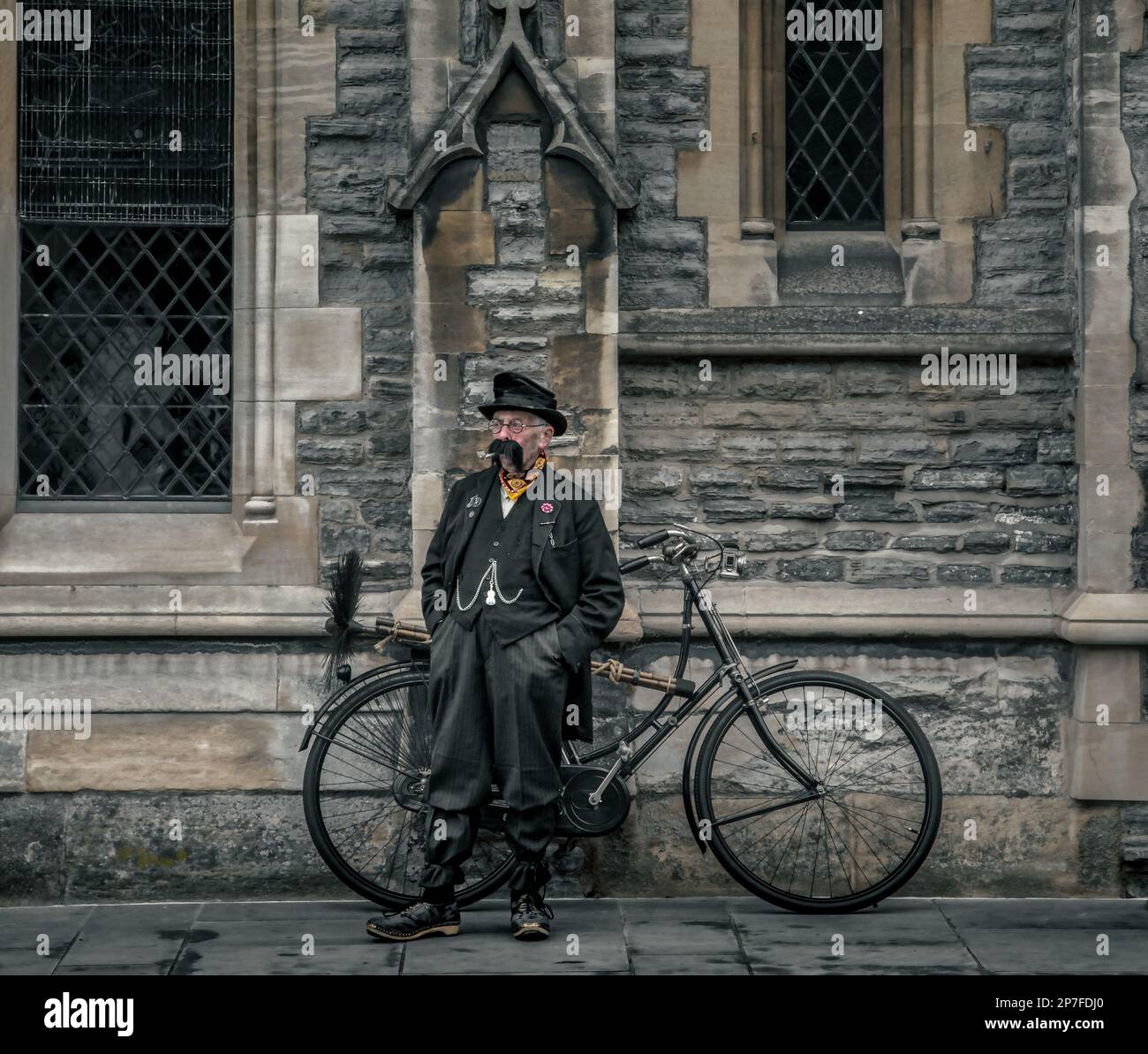 An Victorian chimney sweep with a large moustache standing next to his bicycle. Stock Photo