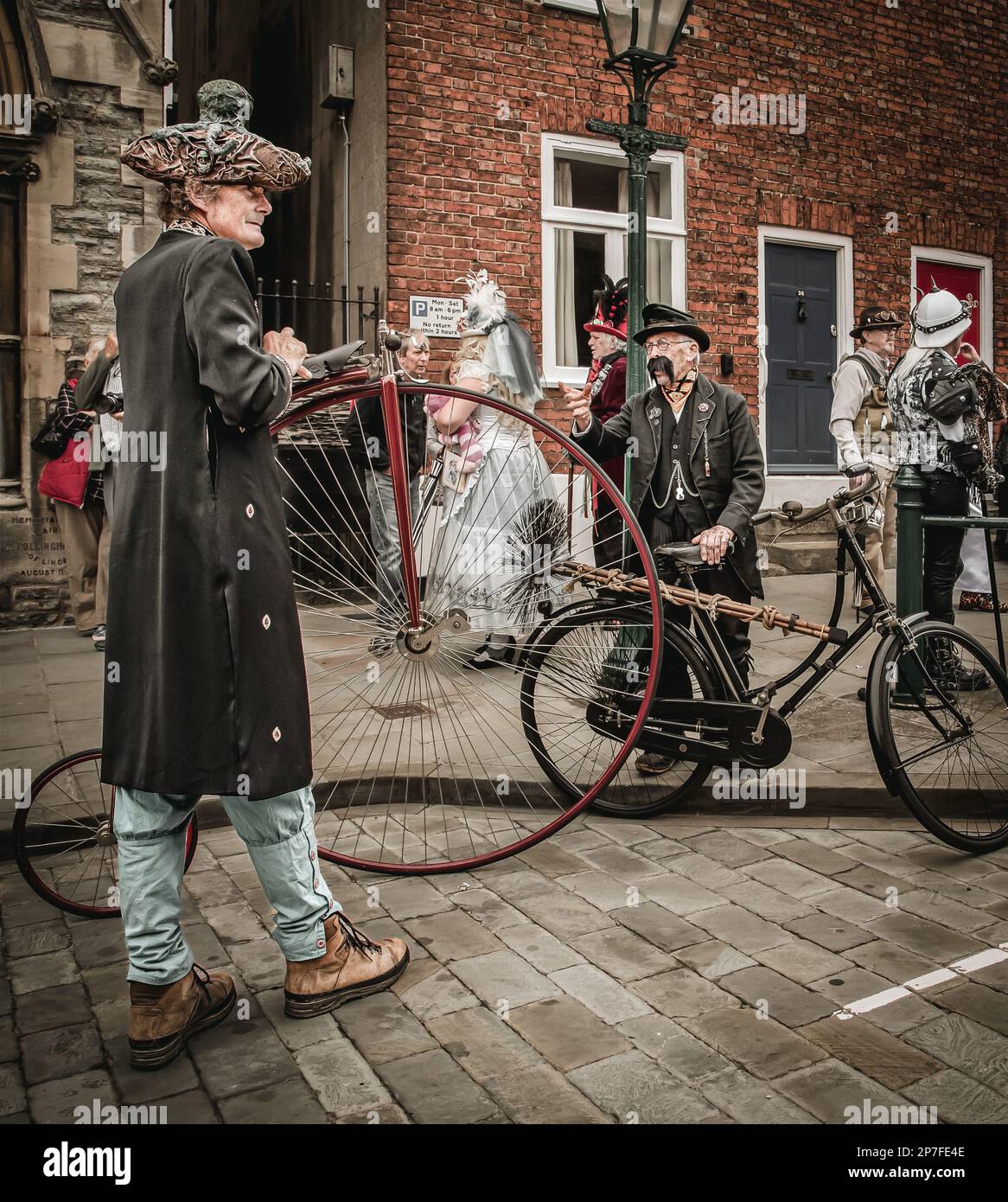 A Victorian chimney sweep and a man with a penny farthing feature in this surreal retro futuristic street scene. Stock Photo