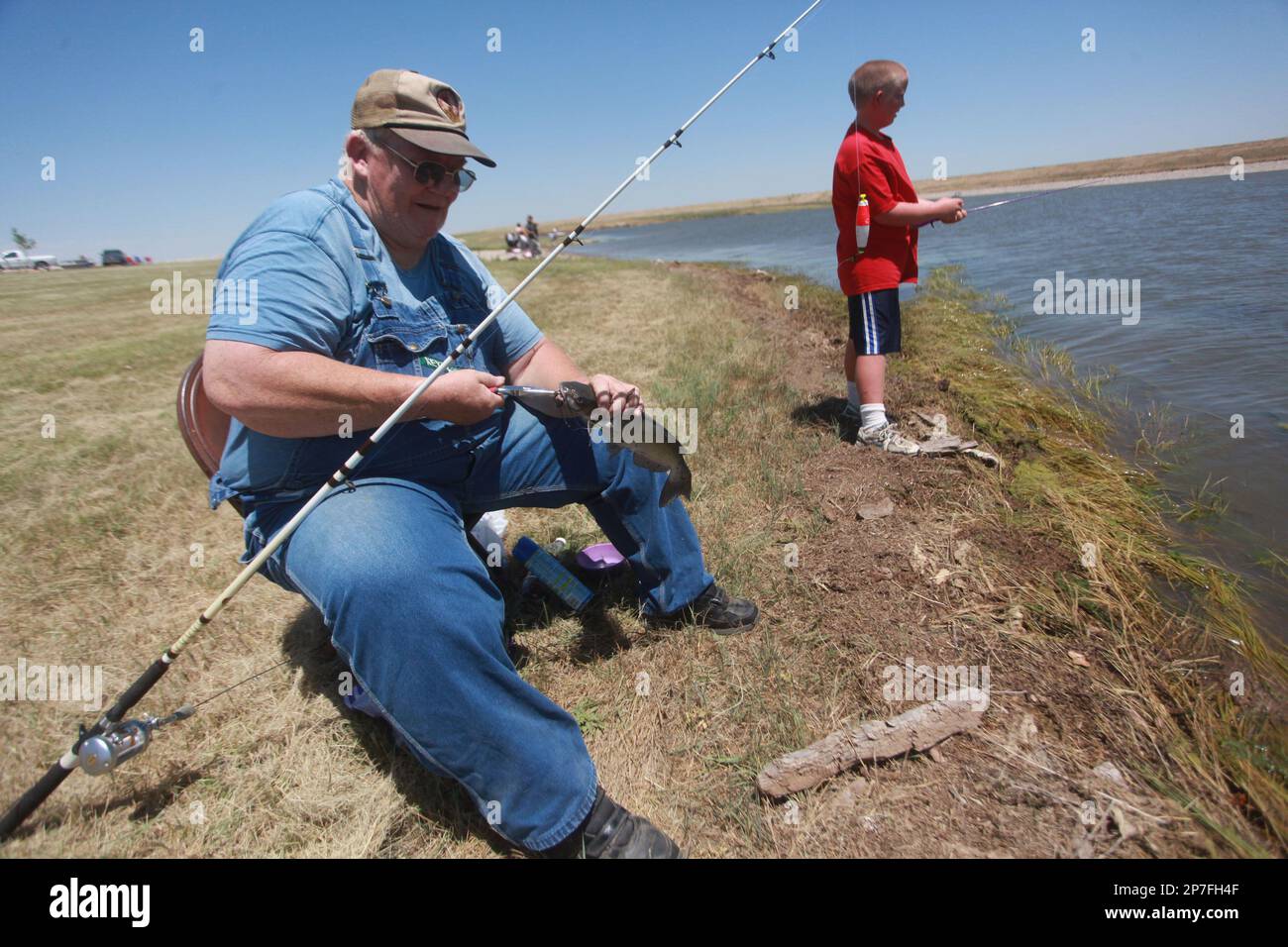 Stephen Clepper unhooks a catfish he caught Saturday, June 26, 2010, as ...