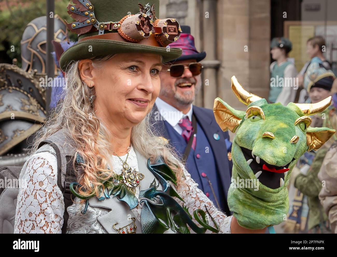 A female steampunk holding up a dragon head puppet. Stock Photo