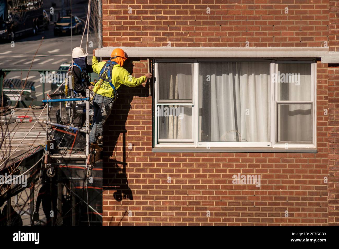 Workers on scaffolding perform citymandated facade inspection and repair on the exterior of an