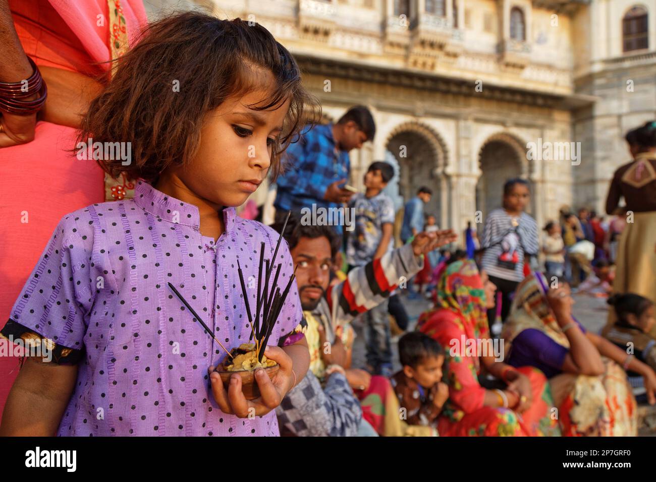 UDAIPUR, INDIA, November 4, 2017 : Small girl prepares offerings. On the full moon day, an Hindu ceremony of light stands on the banks of the lake of Stock Photo