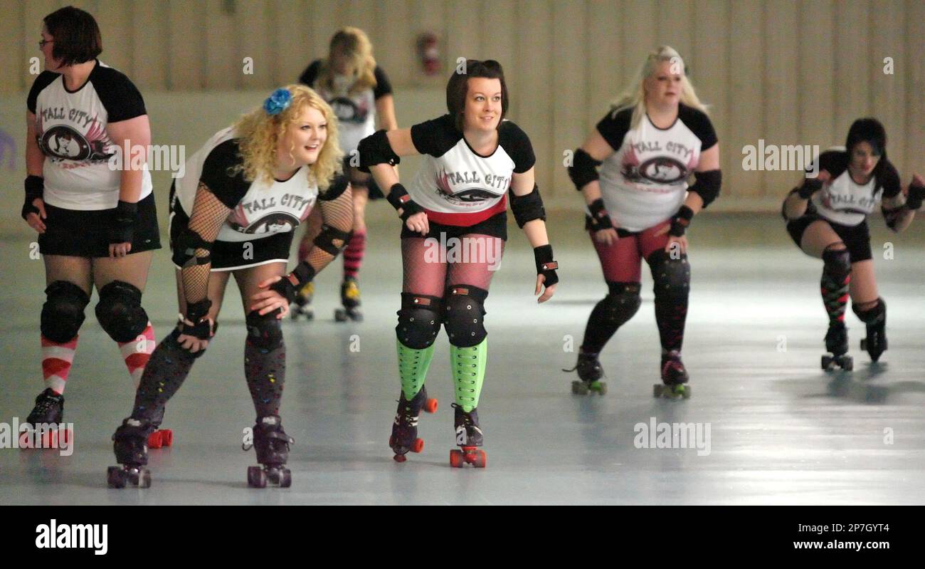 In this April 13, 2010 photo, Elizabeth Kelton, second left, and Amanda  Iley , third right, round a turn during a roller derby workout at KC's  Nutty Roller in Midland, Texas. (AP